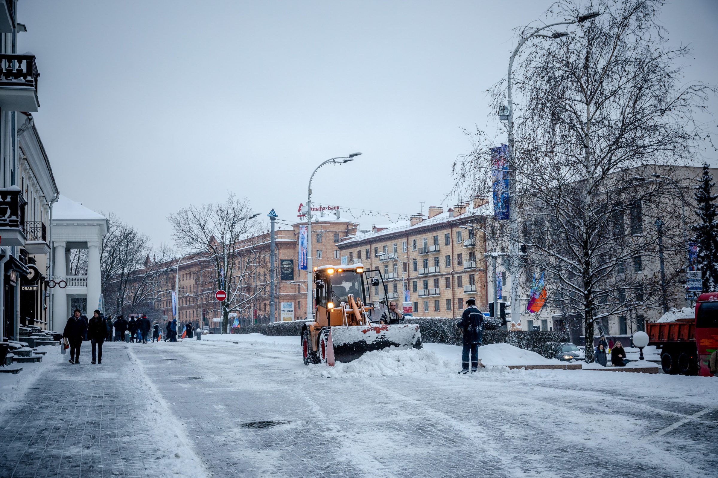 Snowplow clearing city street in winter.