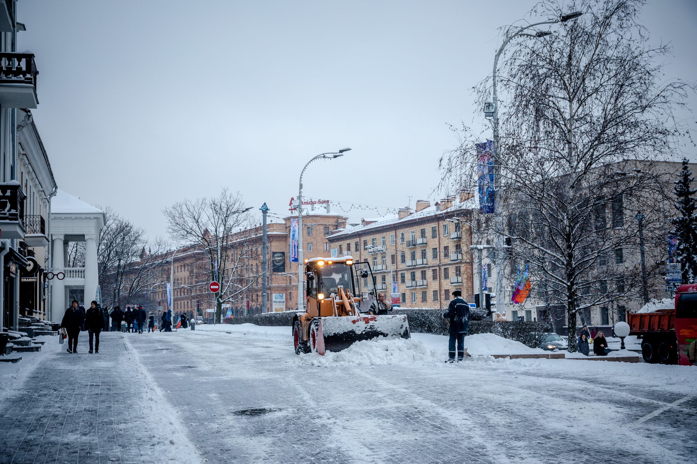 Snowplow clearing snow from city street.