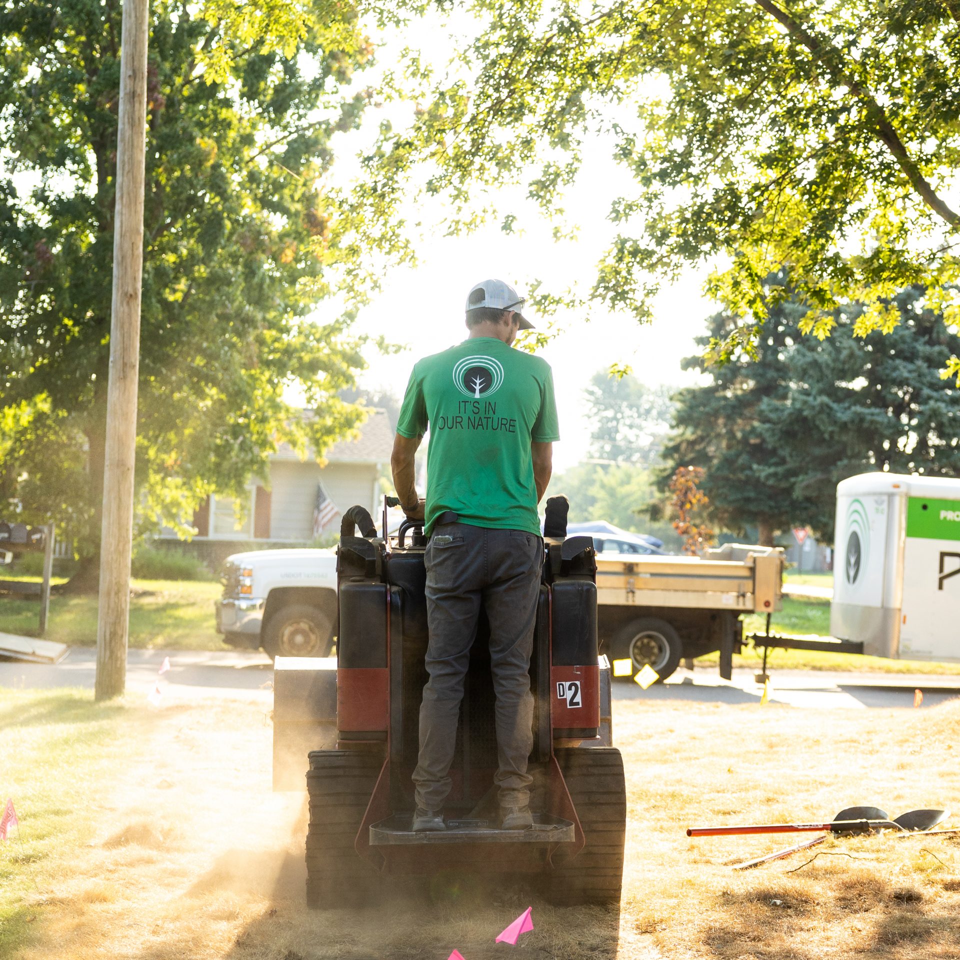 Worker operating machinery in sunny outdoor setting.