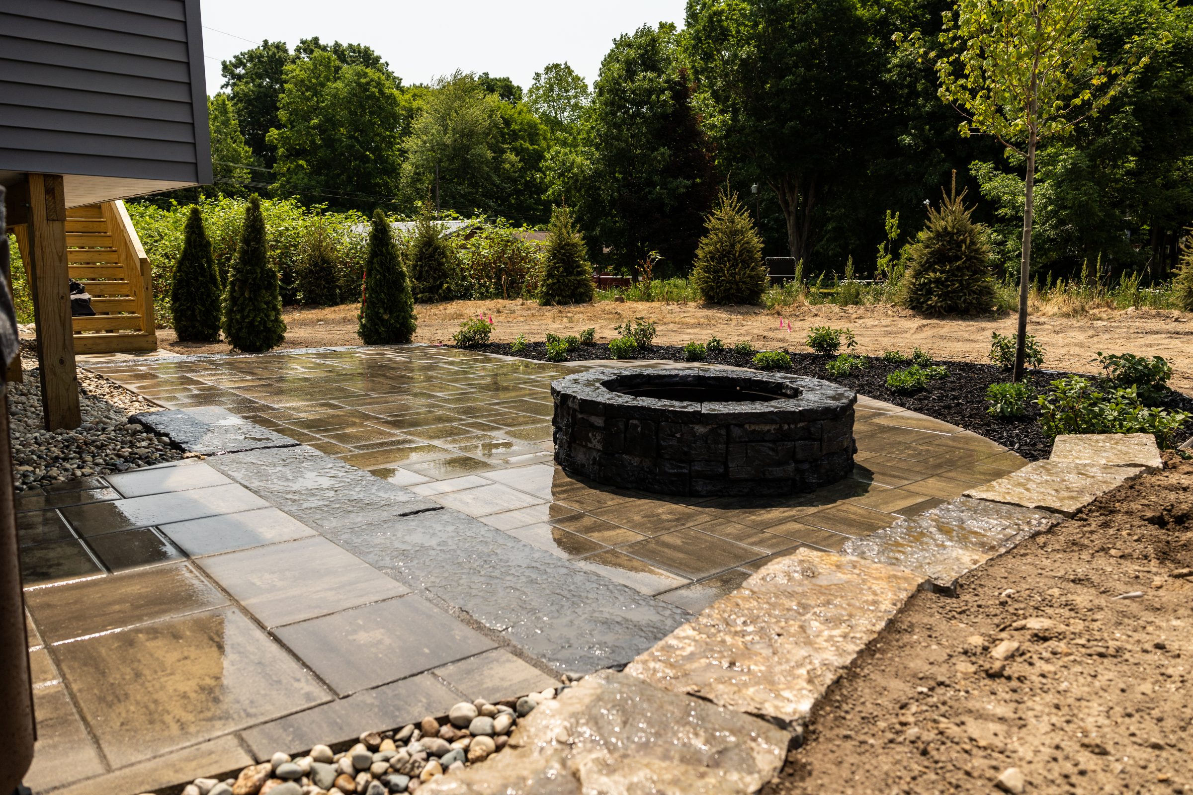 Backyard patio with central stone fire pit.