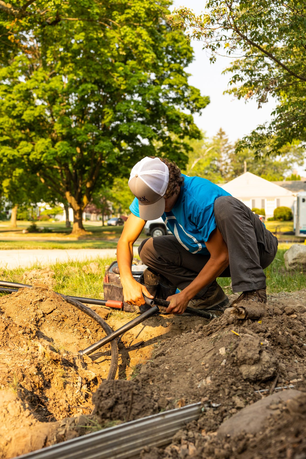 Person installing outdoor cables in garden.