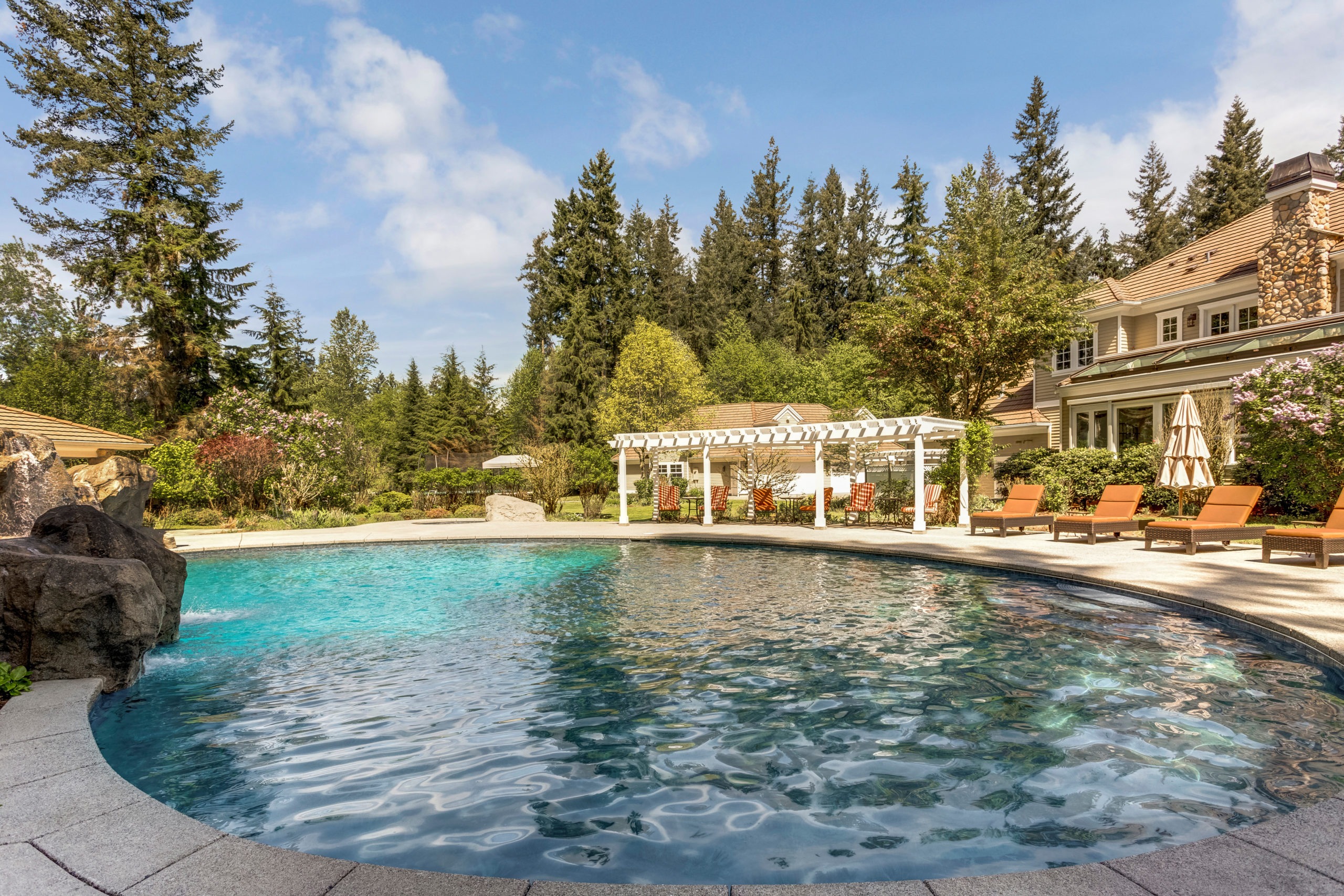 Luxurious outdoor pool with lounge chairs and pergola.