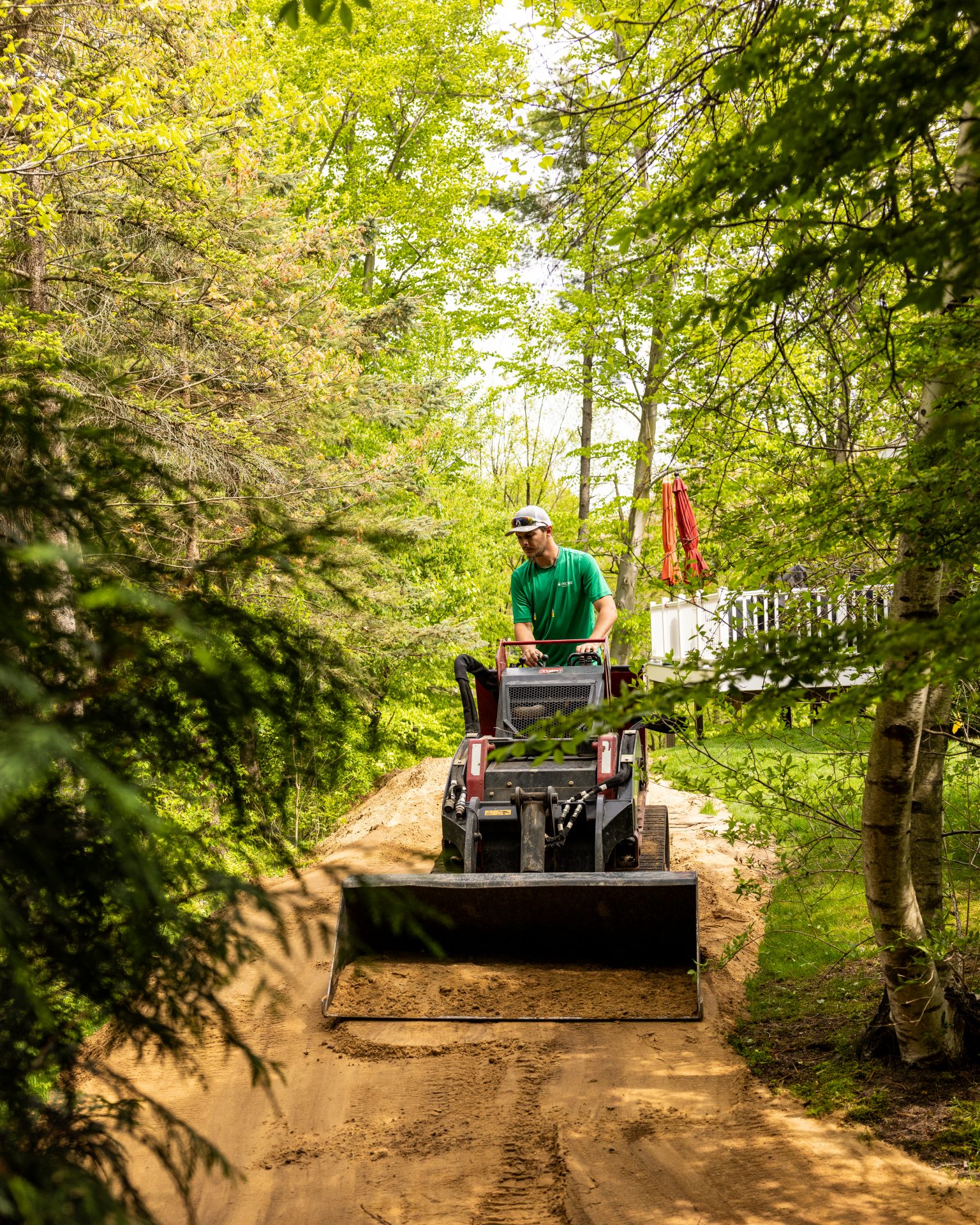 Person operating bulldozer on forest path.