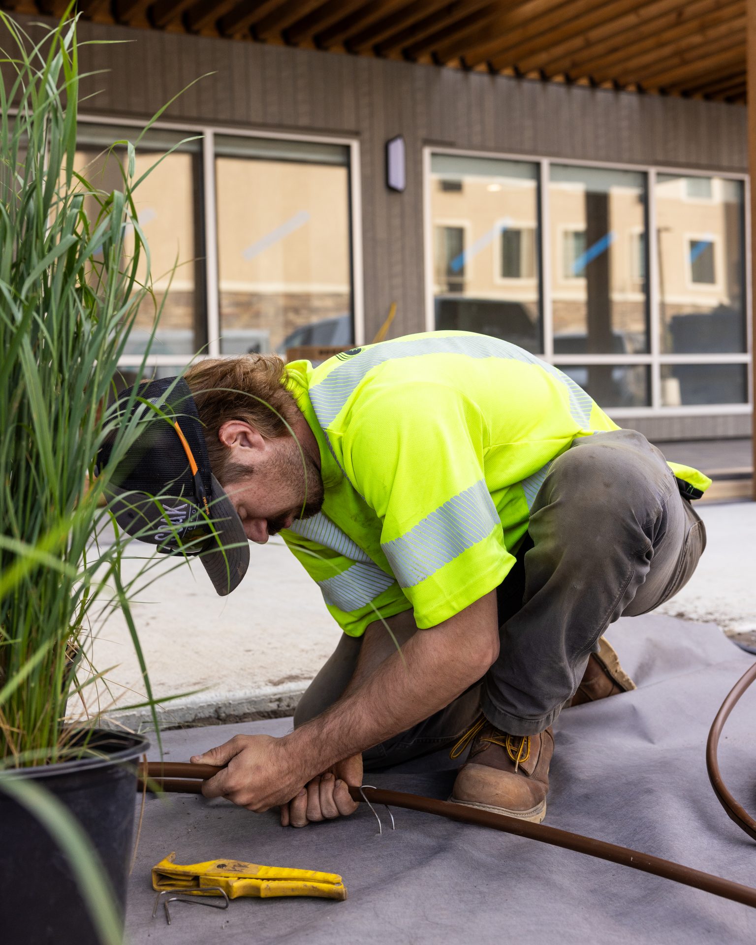 Worker installing landscape irrigation system outdoors.