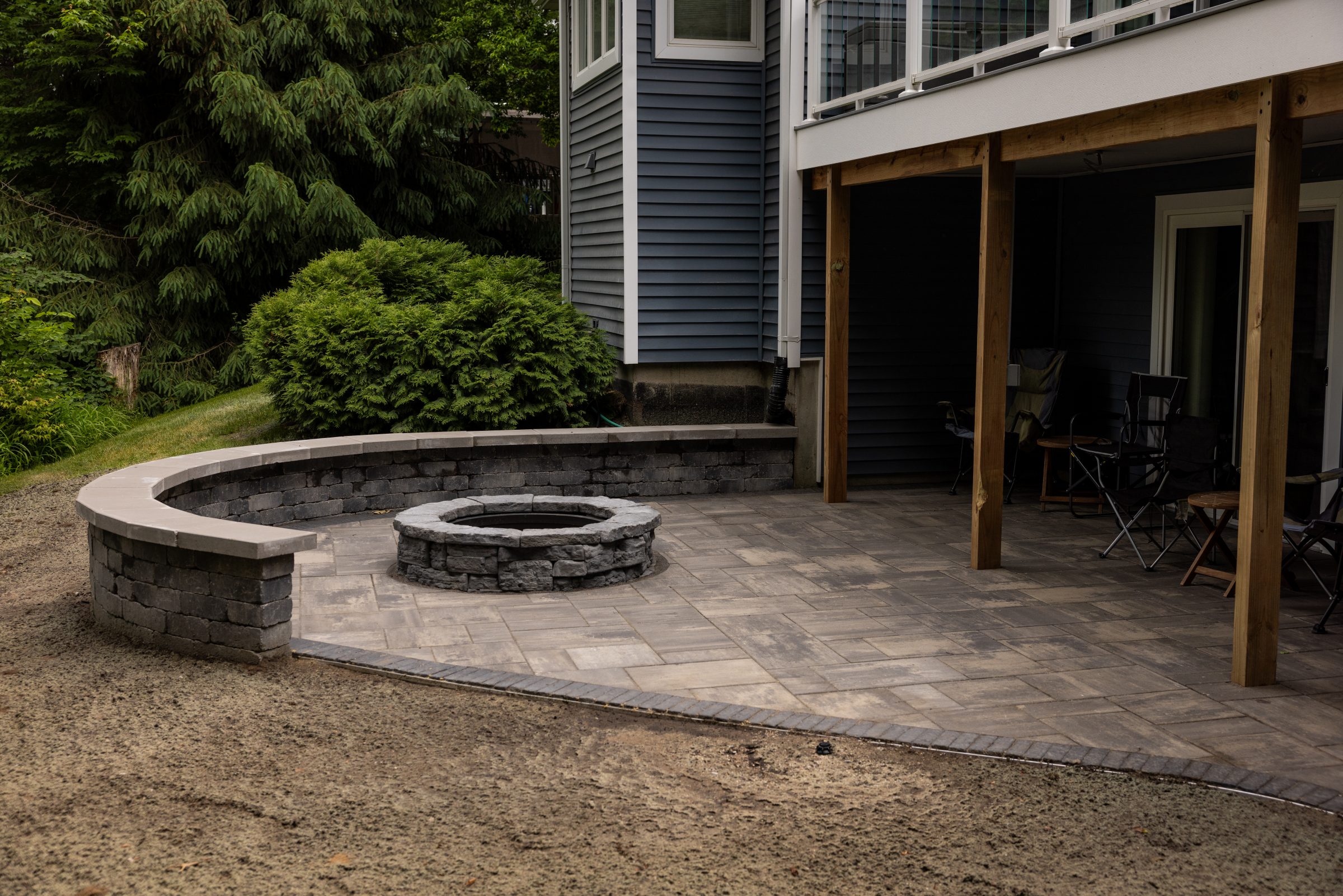 Backyard patio with fire pit and seating area.