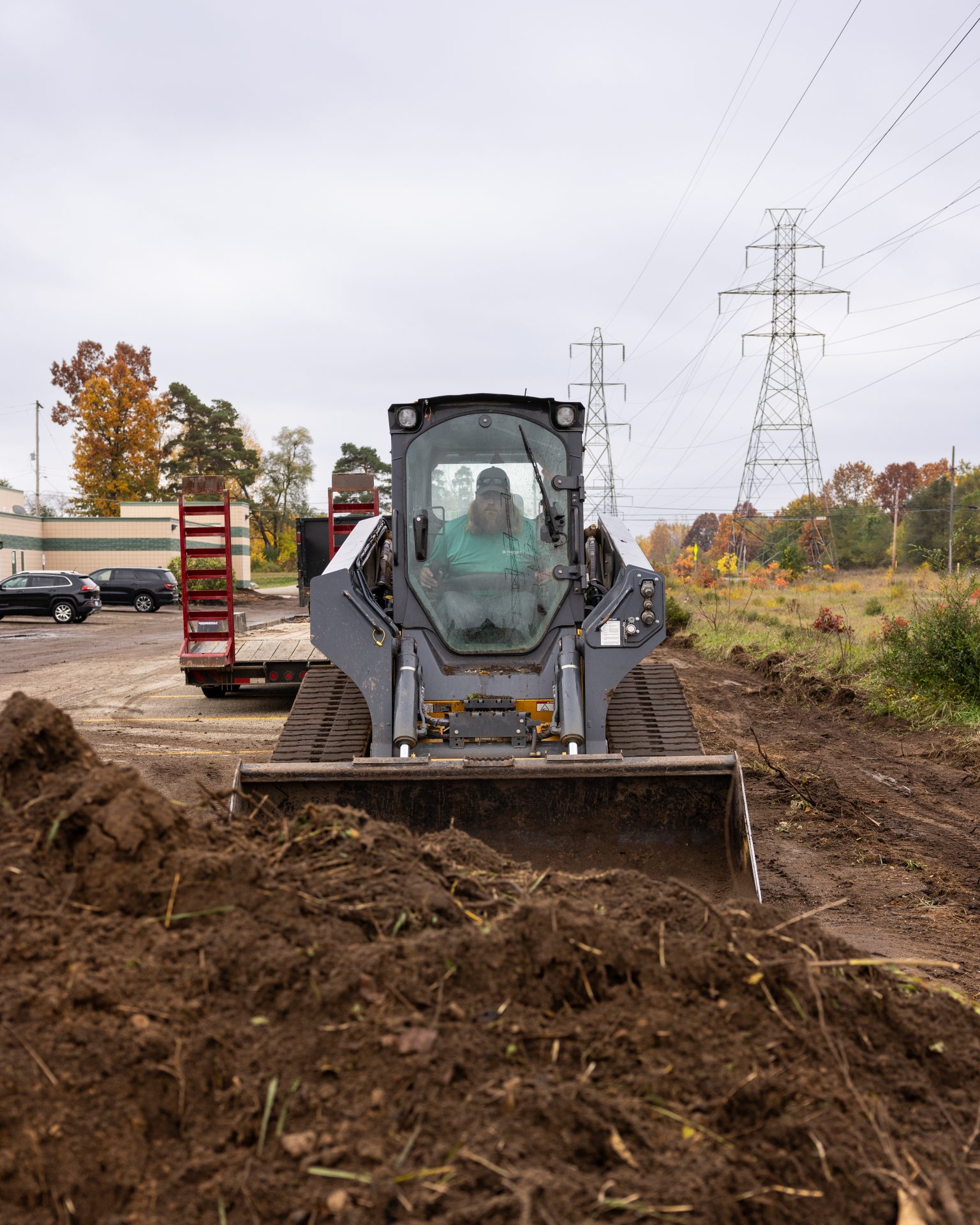 Excavator on construction site clearing dirt pile