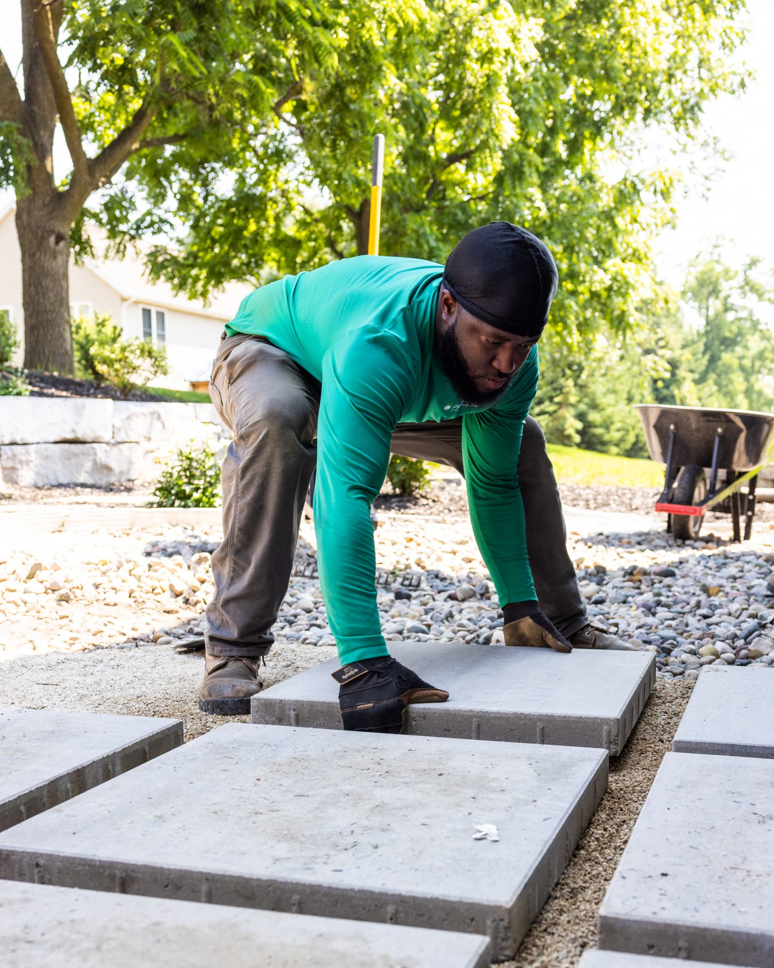 Worker placing concrete slabs in garden