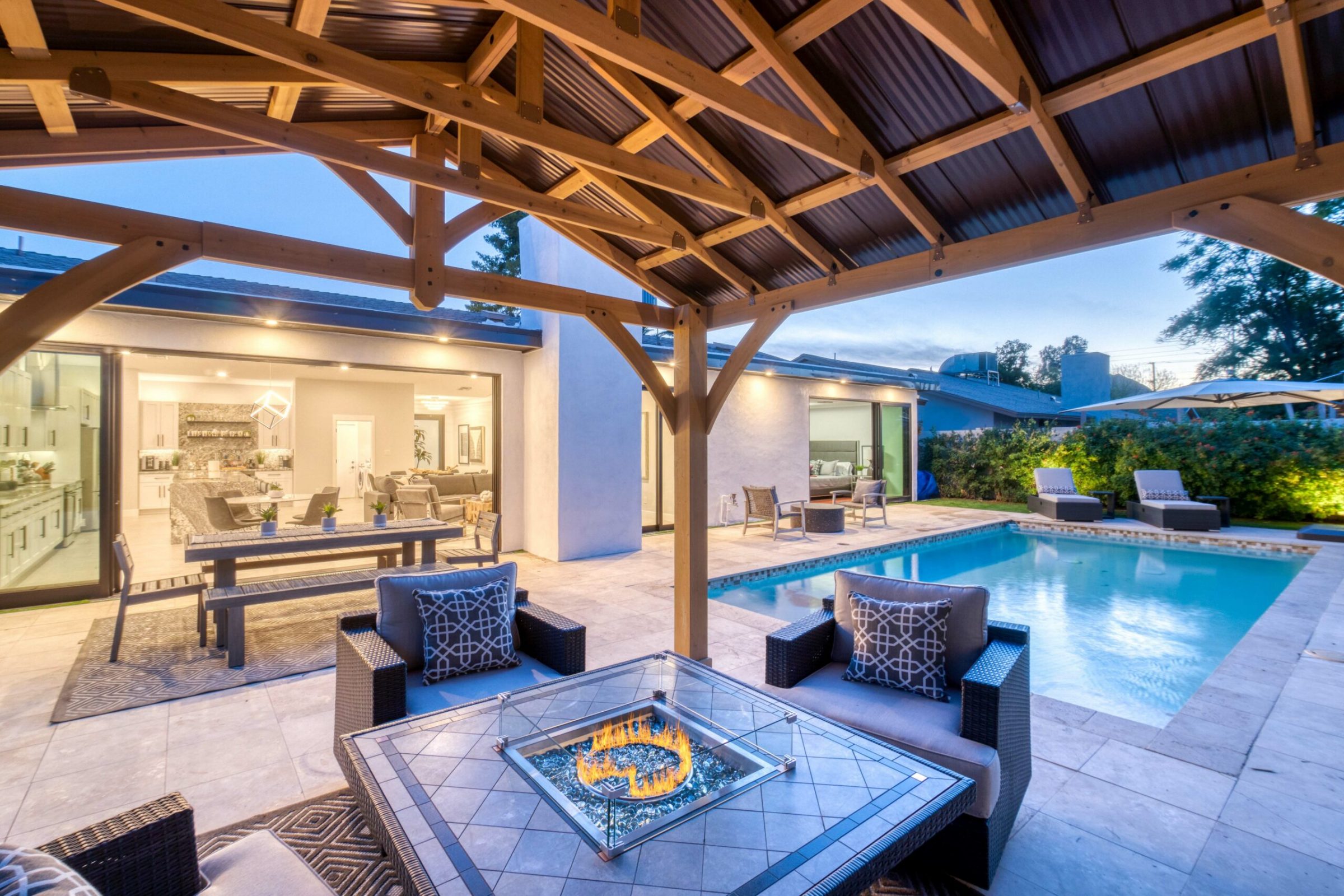 Modern outdoor patio with pool and fire pit.