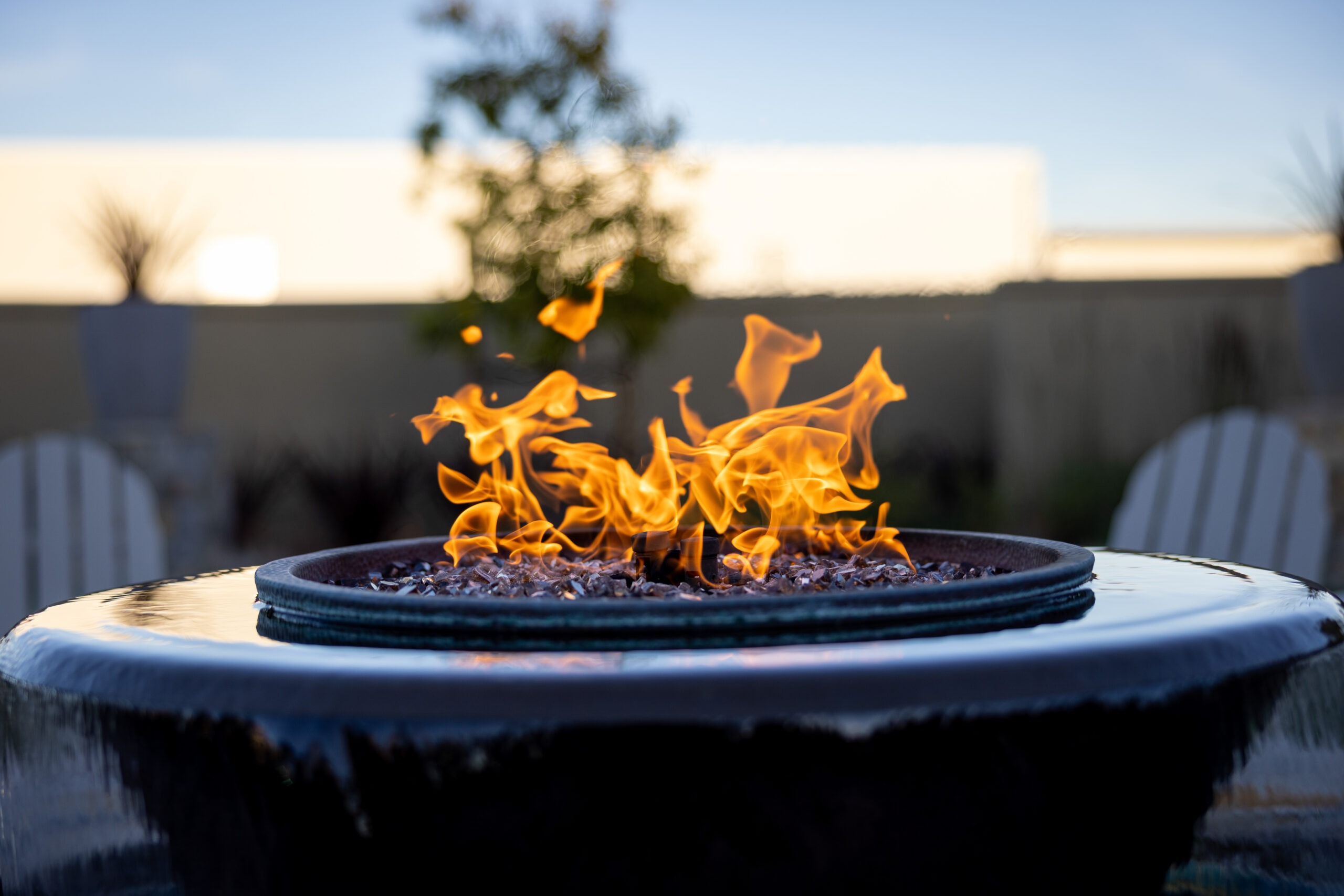 Fire pit with flames on patio.