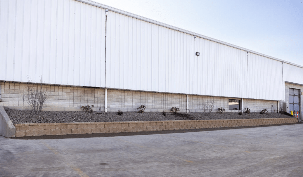 Large industrial warehouse exterior with minimal landscaping.