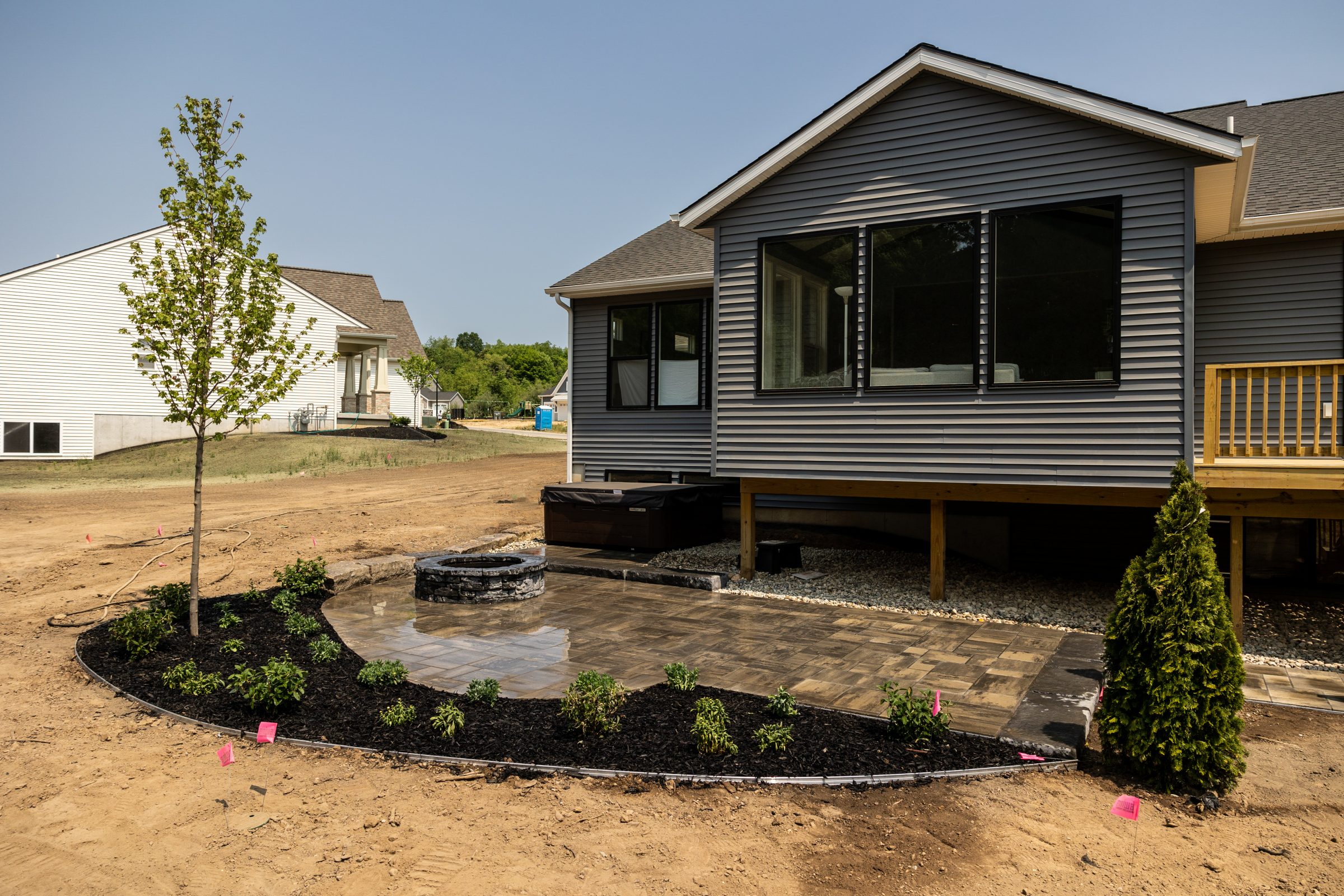 Newly landscaped backyard with patio and tree.
