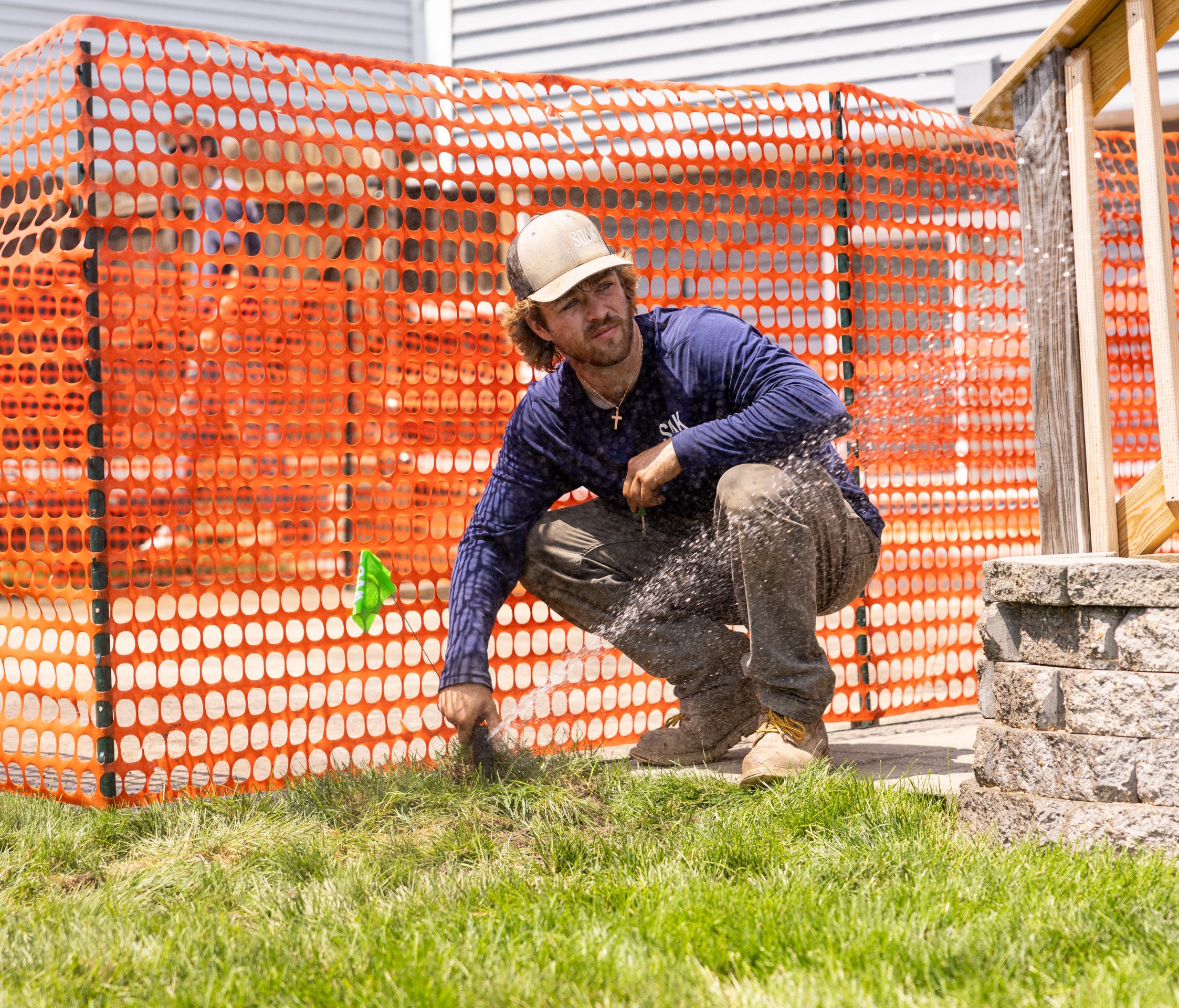 Man working outdoors with construction fence.
