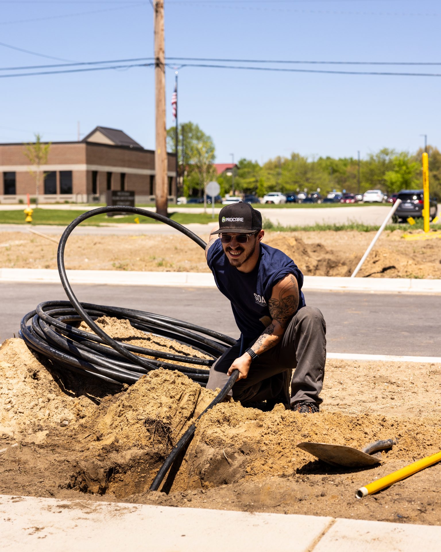 Worker installing fiber optic cables underground.